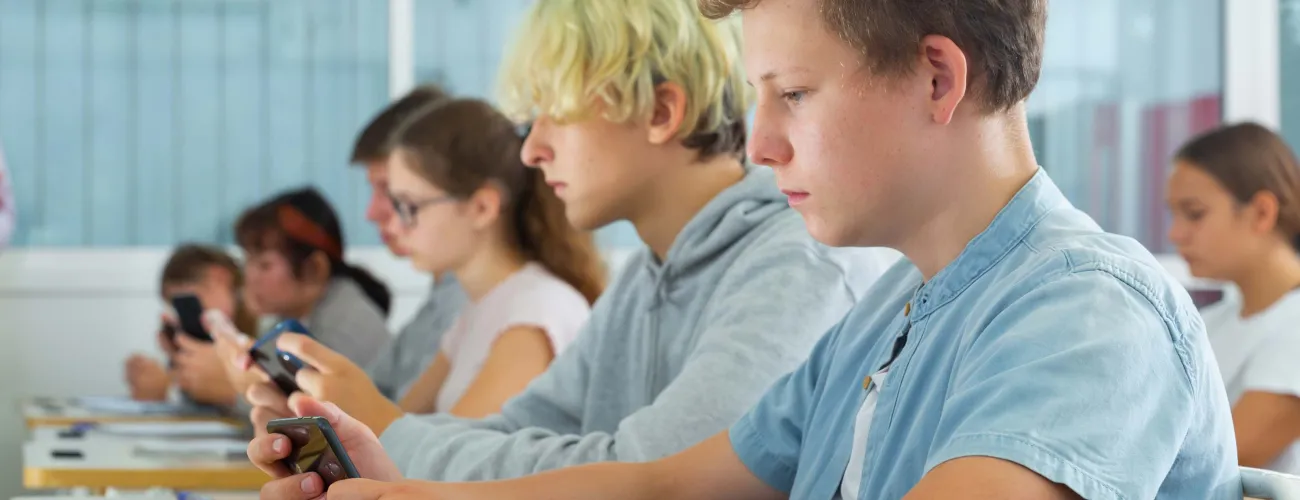 Un élève sur son smartphone dans une classe de cours