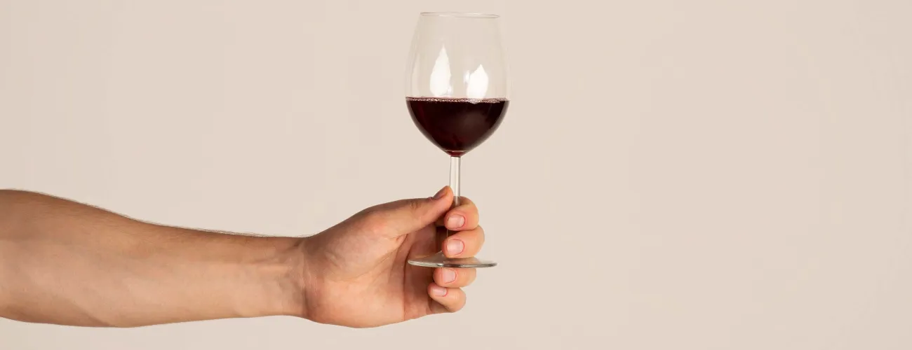 Un homme tient un verre de vin rouge