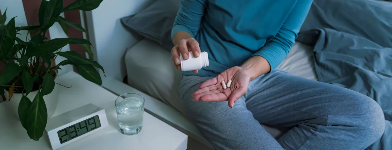 Une femme prend de la mélatonine pour dormir et éviter les insomnies
