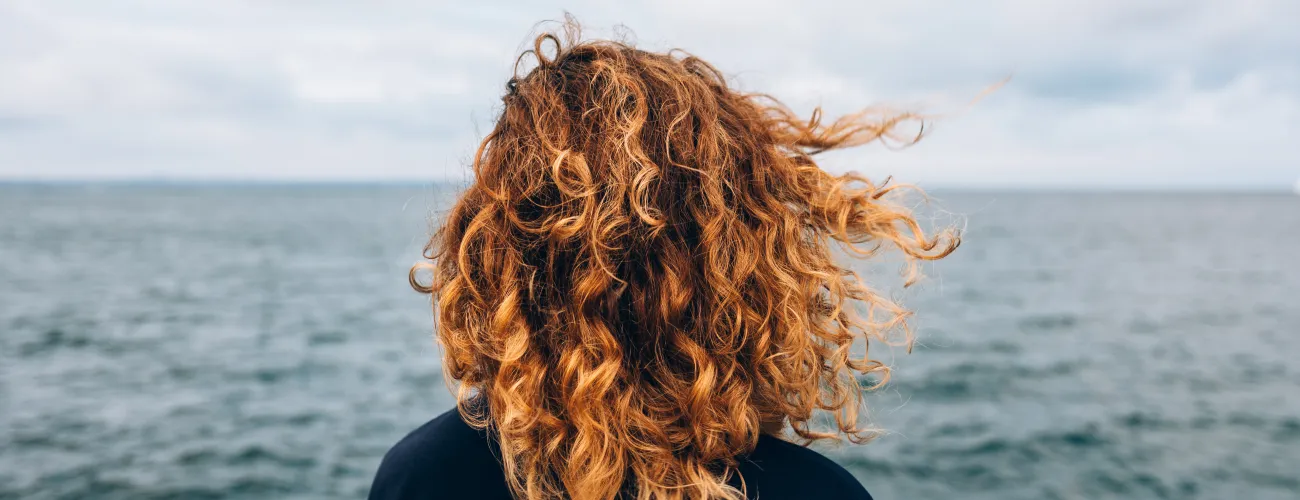 Une femme regarde la mer et son horizon