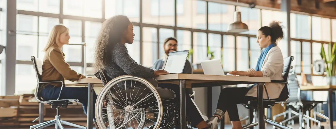 personnes en chaise roulante sur un plateau de travail avec ses collègues