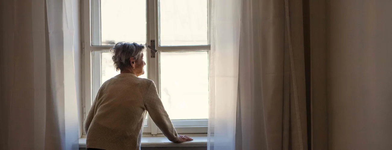 Femme regardant par la fenêtre