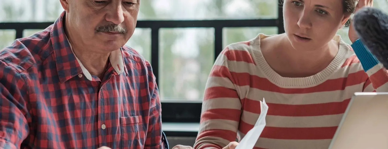 Un homme et une femme assis l'un à côté de l'autre, regardent un document.