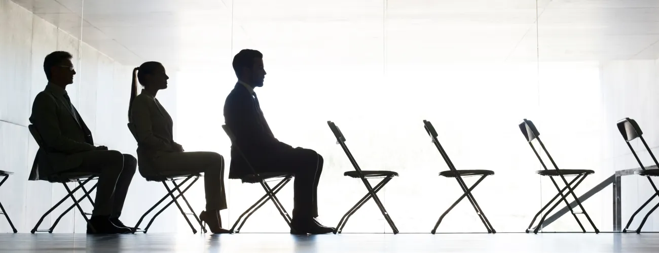 deux hommes et une femme sont assis sur des chaises pliantes
