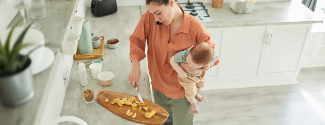 maman qui cuisine avec un bébé dans les bras