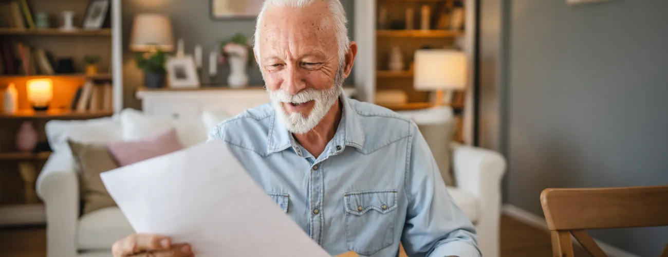Un monsieur âgé reçoit une acceptation d'aide sociale grappa