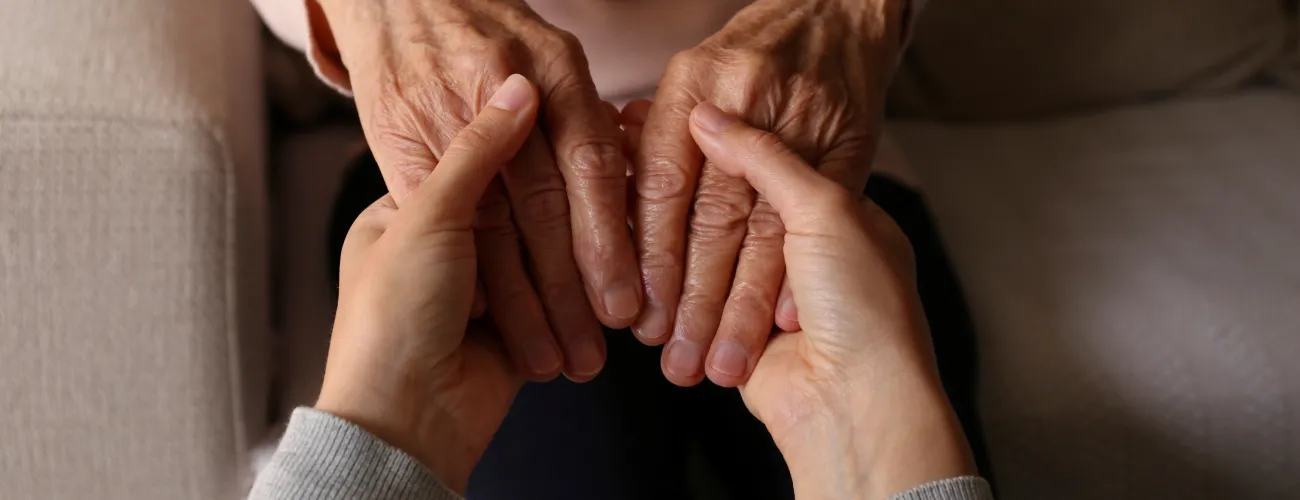 main d'une personne âgée et plus jeune se tenant en signe de solidarité