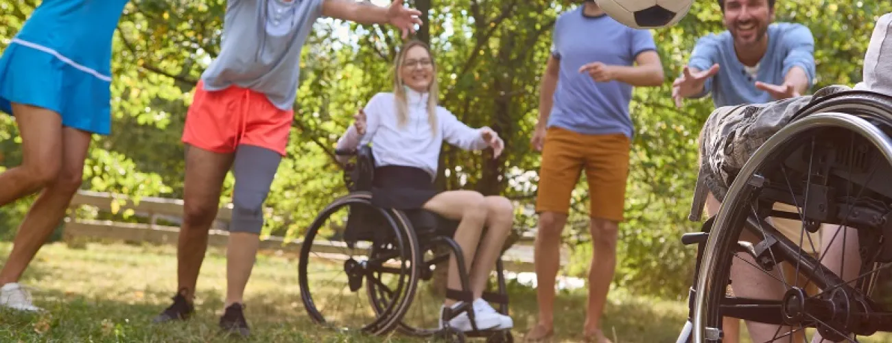 Des personnes valides et en situation de handicap pratiquent ensemble une activité avec un ballon.