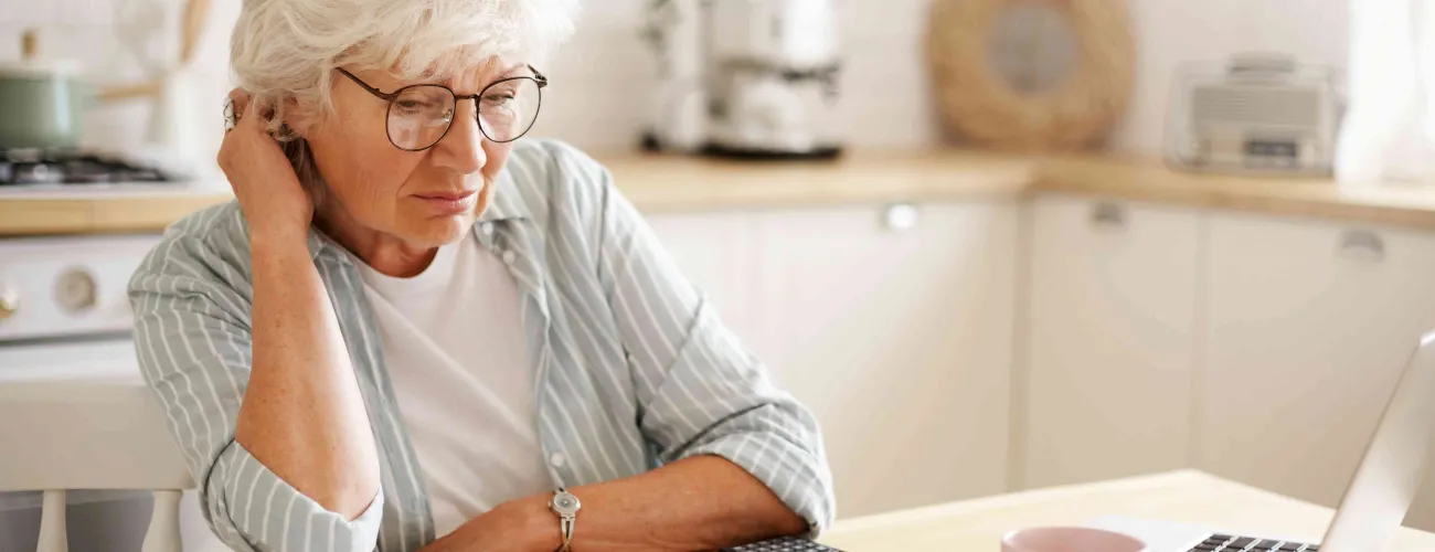 Une femme lit un document, assise à une table