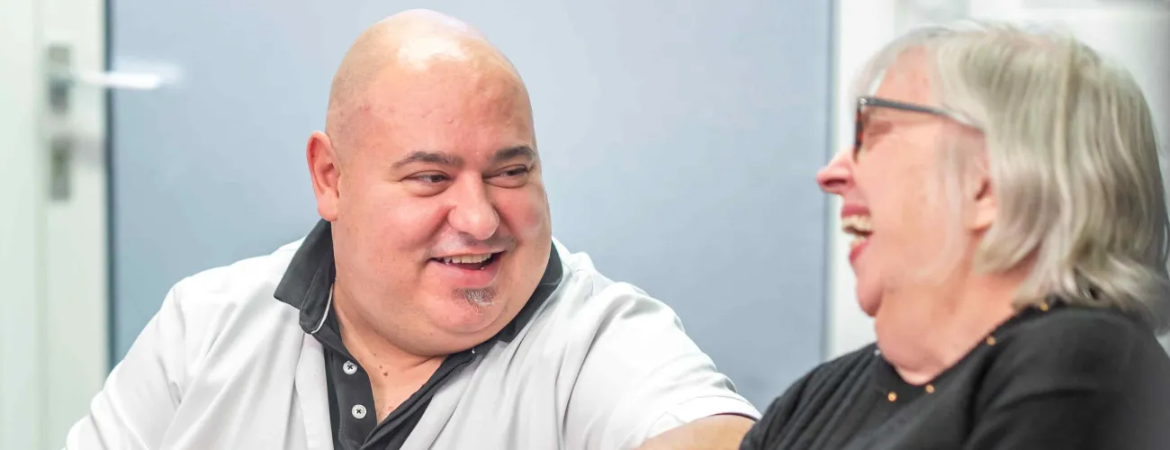 Un infirmier à domicile soigne une patiente assise dans son fauteuil