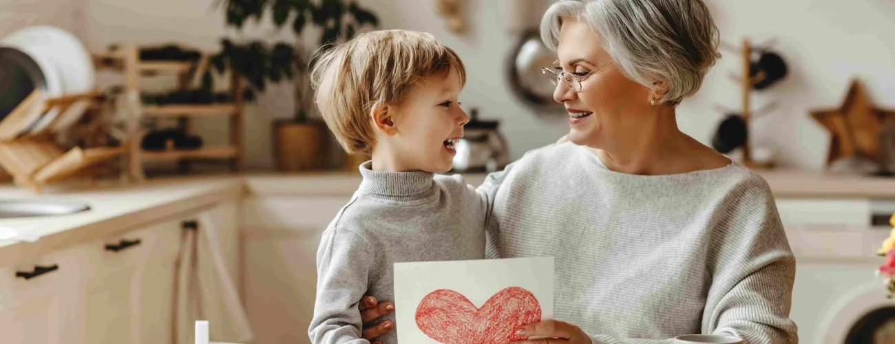 Une femme et son petit fils regardent un dessin avec un coeur