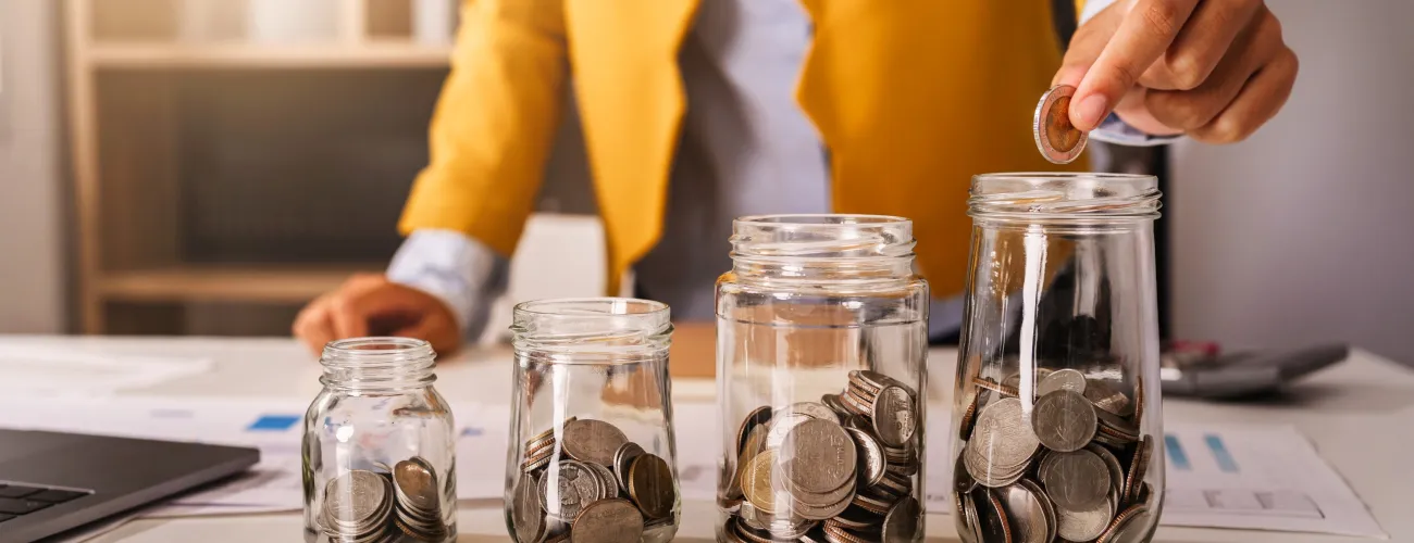 plusieurs bocaux plus ou moins remplis avec de l'argent 