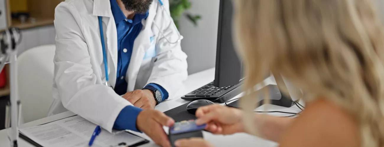 Un médecin montre sa facture à une patiente.