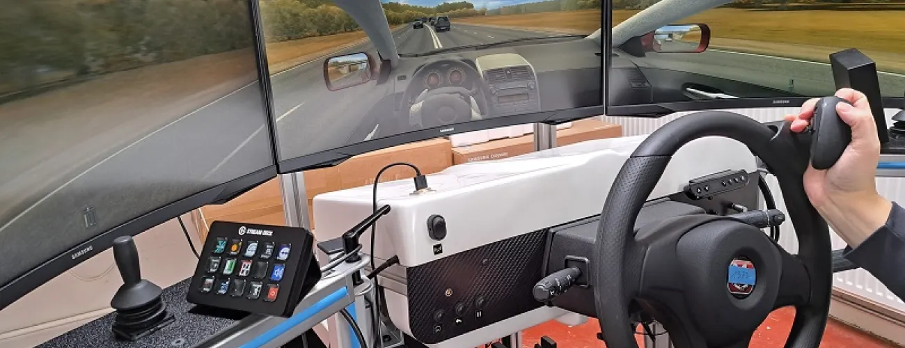 Un simulateur de conduite avec un grand écran montrant une route.