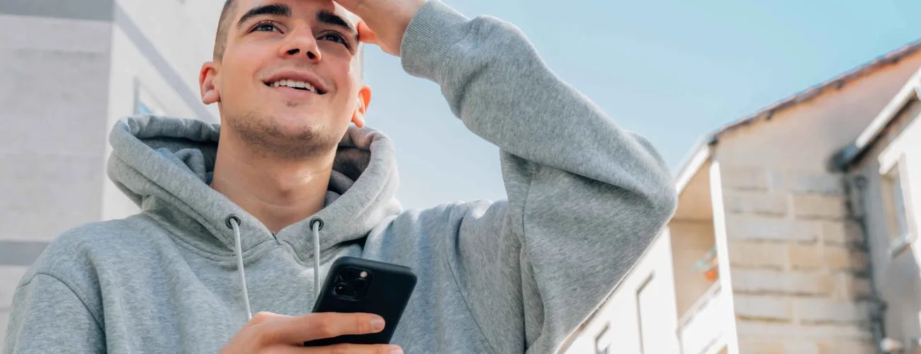 Un jeune sur son GSM regarde en l'air