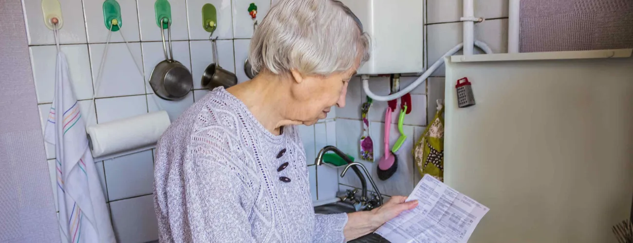 Une dame âgé allume sa gazinière