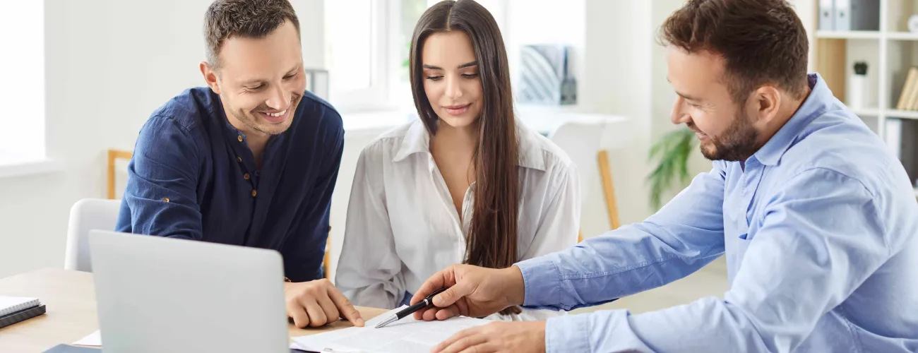 Deux hommes et une femme consultent des informations sur un ordinateur