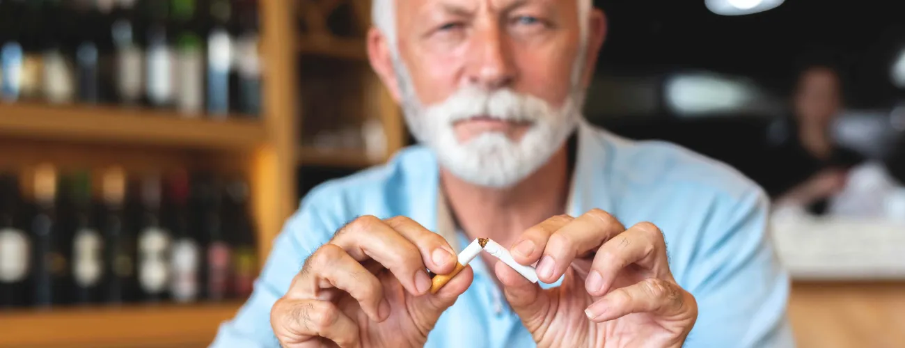 un monsieur brise une cigarette en deux