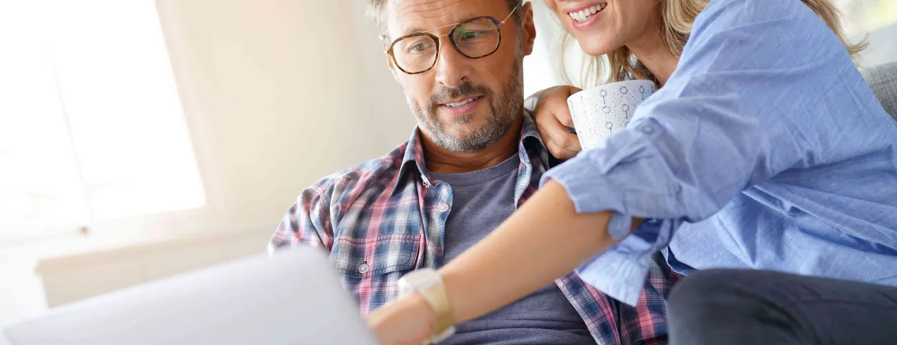 Un couple assis derrière un ordinateur.