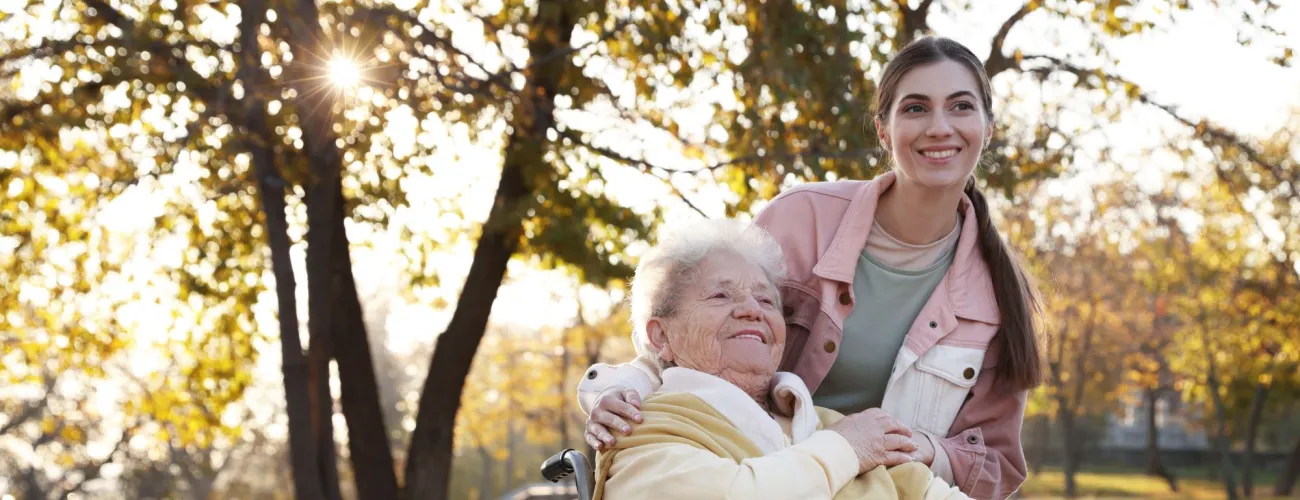 Une vieille dame et une garde à domicile, posent en souriant, montrant le lien qui s'est tissé au fil du temps passé ensemble