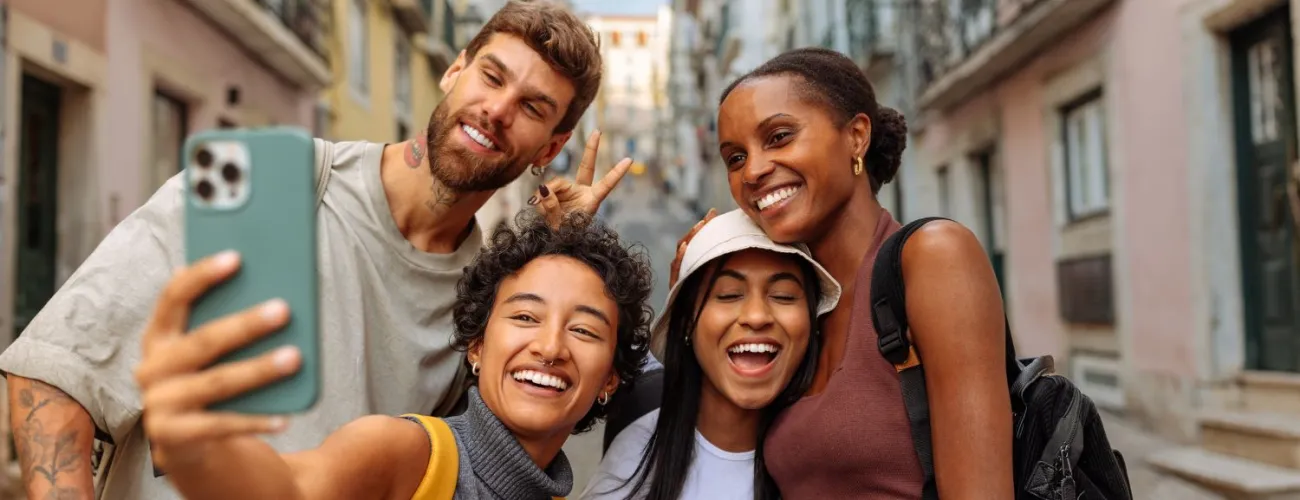 4 jeunes touristes font une photo avec leur téléphone
