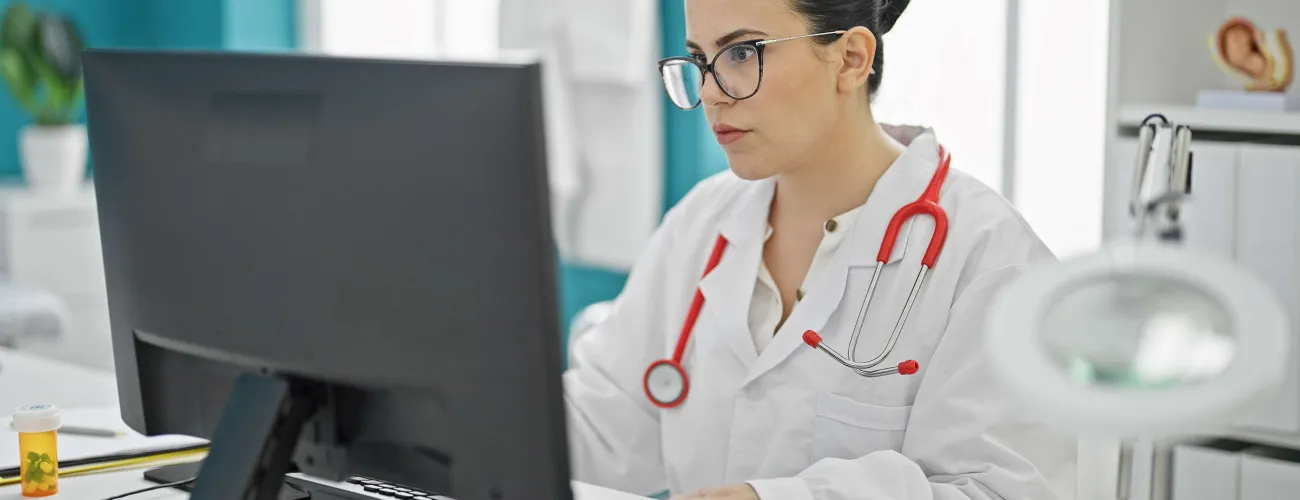 une femme médecin encode l'attestation de soins sur son ordinateur