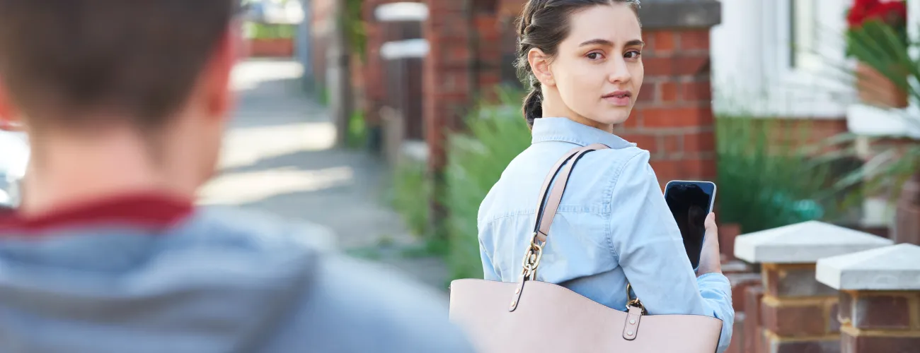 une femme se retourne face à un homme qui la suit