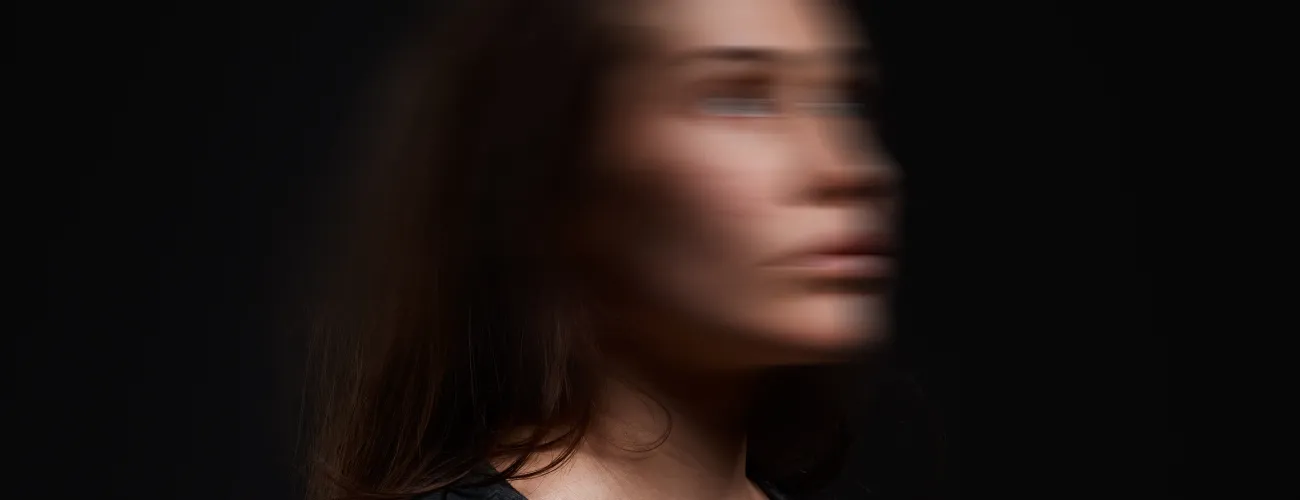 Image d'une femme debout dont le visage est flouté comme si elle vivait un séisme