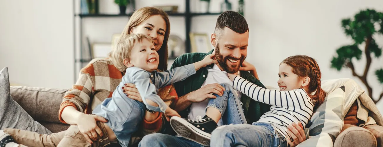 Une famille souriante assise dans un canapé