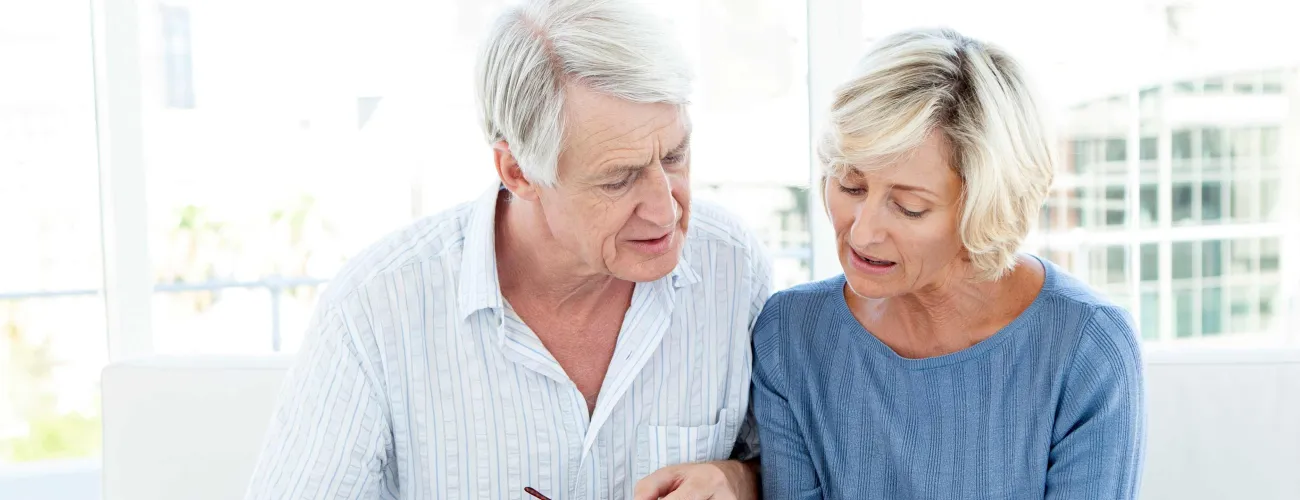 Un couple de seniors regarde une facture d'hôpital