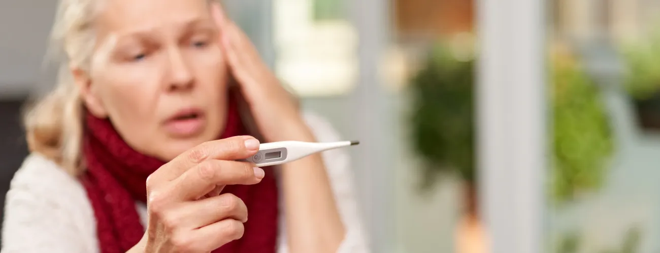 Une femme regarde un thermomètre
