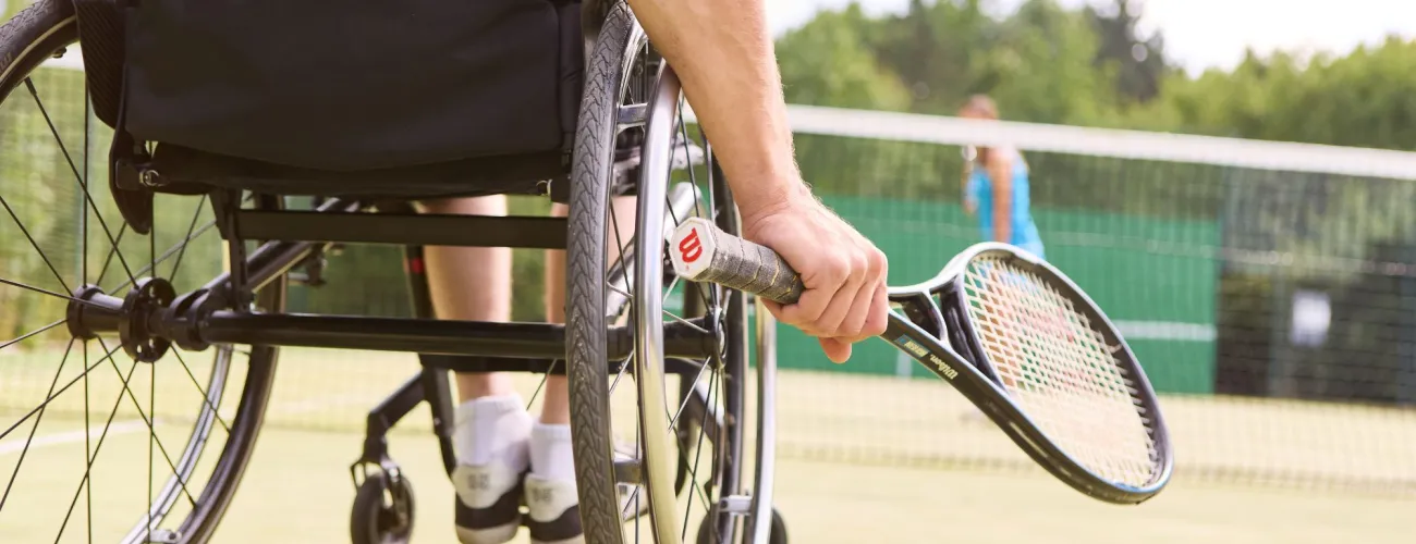 une personne en chaise roulante joue au tennis