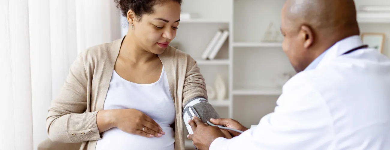 une femme enceinte se fait prendre la tension par son médecin