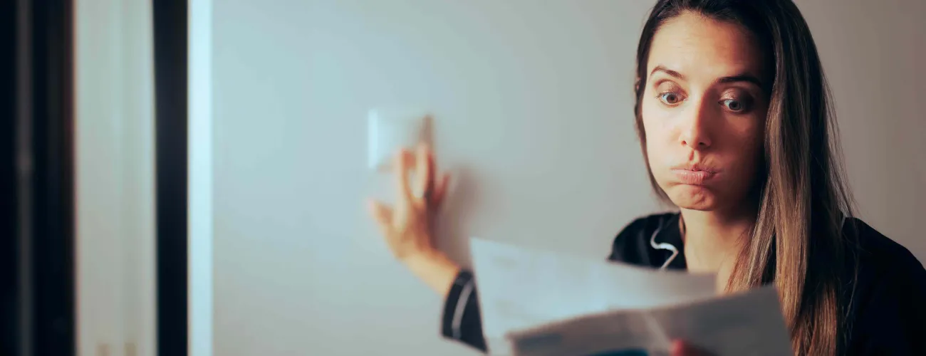 Une jeune femme soupire en parcourant sa facture