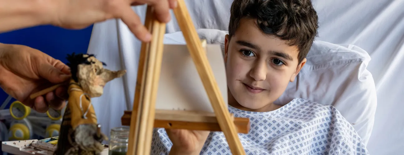 Charlotte peint le profil d’une marionnette à l’aquarelle dans le cadre d’une intervention artistique à l’hôpital.