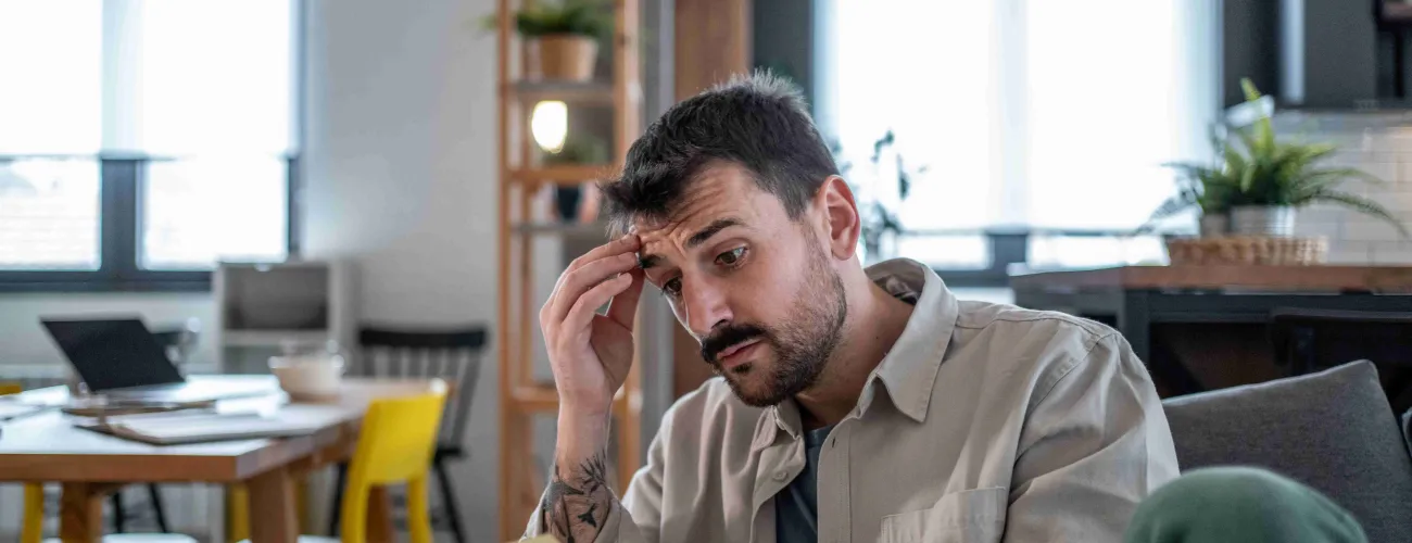 Un homme lit, inquiet, un courrier qu"il a reçu. 