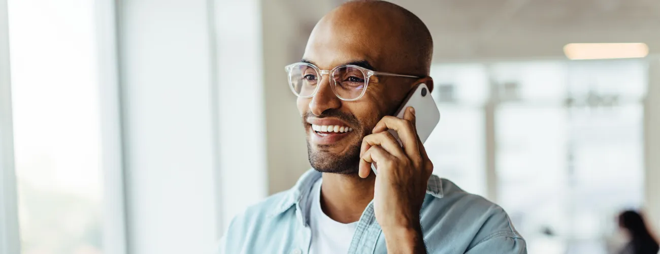 Un homme appelle via son téléphone portable en souriant
