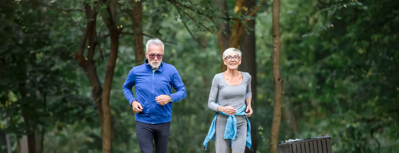 Un homme et une femme en train de courir dans un parc