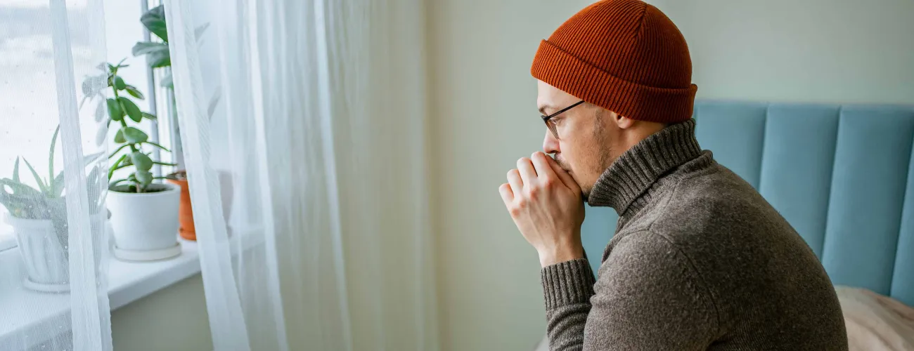 Un monsieur assis devant un radiateur