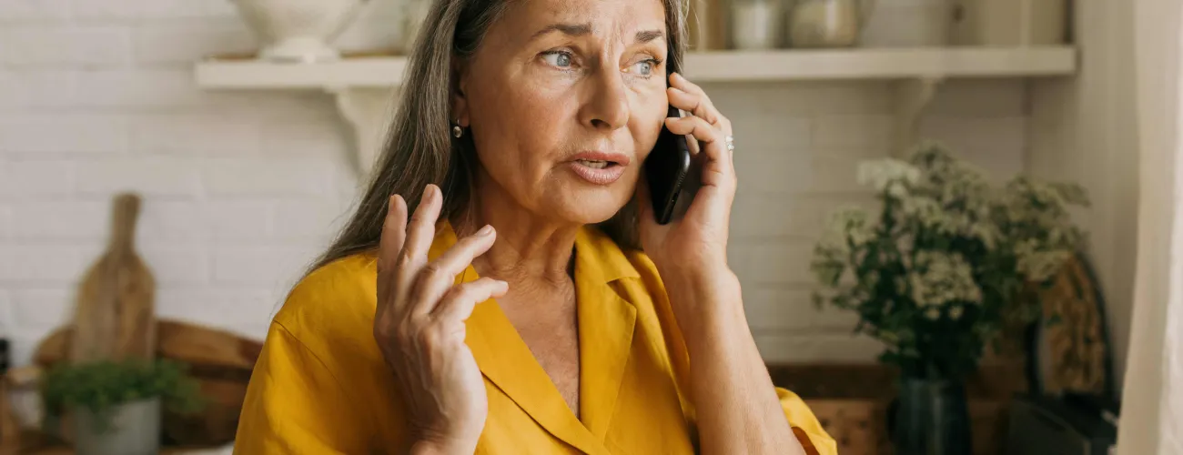 Une dame parle au téléphone de manière inquiète. 