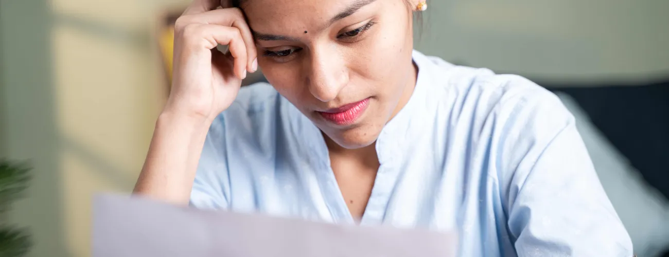 Un femme regarde un document reçu de l'Onem