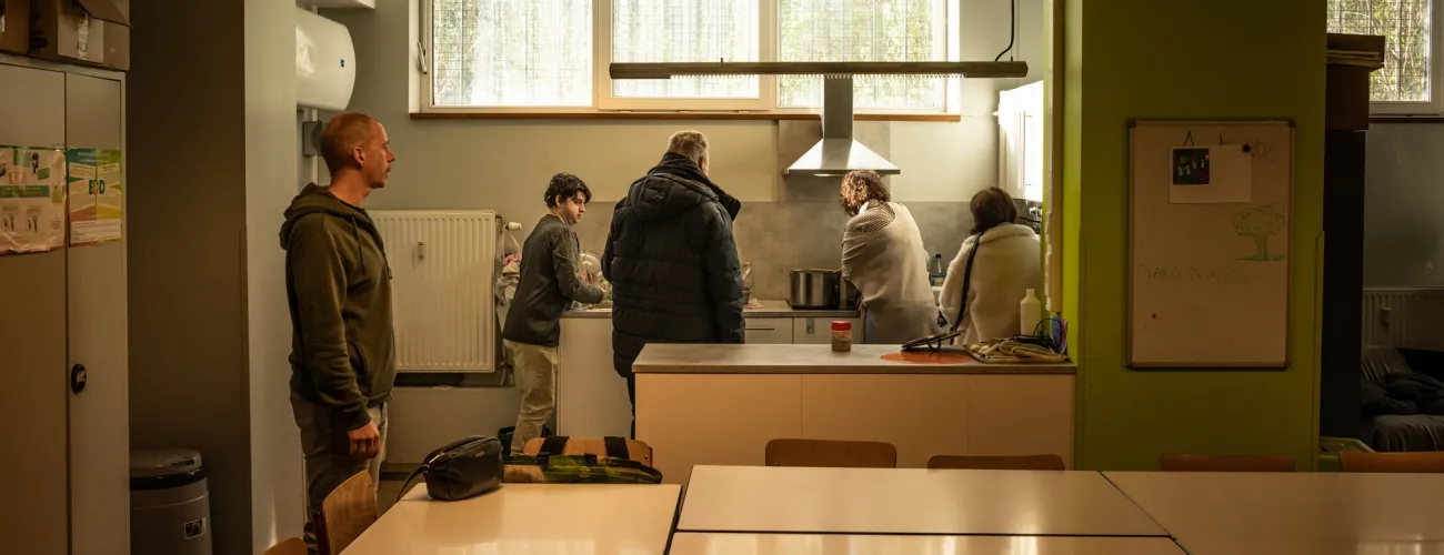 Le groupe de l'atelier de cuisine en train de préparer la salade liégeoise pour les autres bénéficiaires du lieu. 