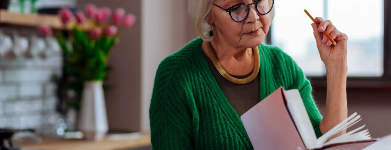 une dame plus agée lit un livre avec intérêt