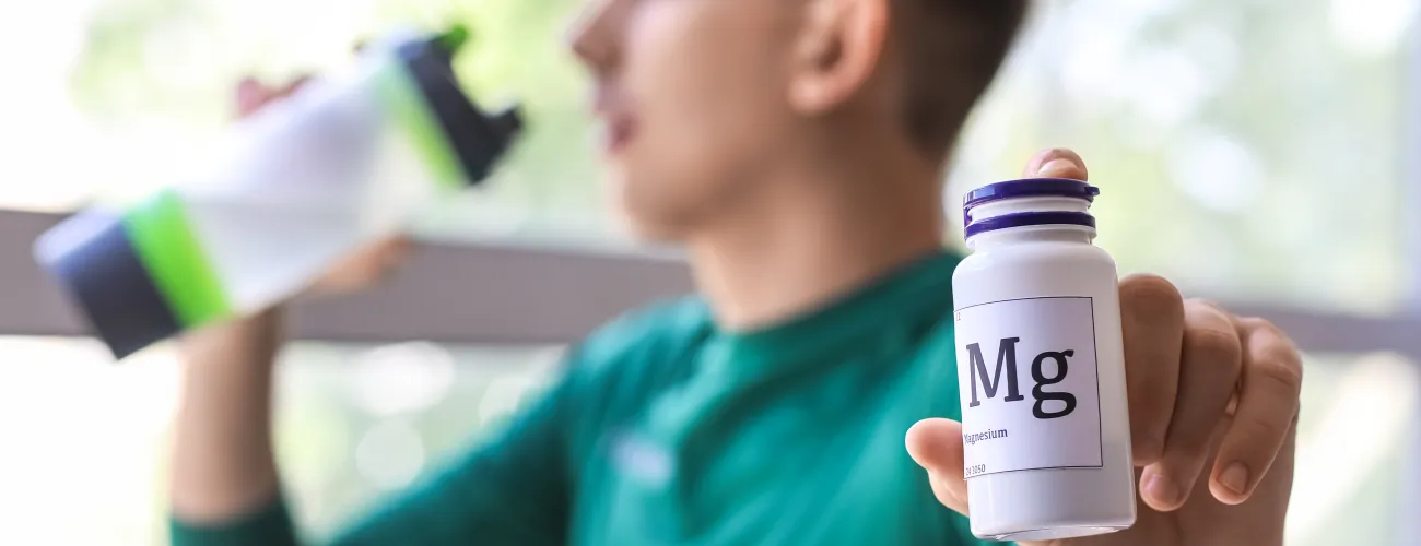 Un sportif tient un récipient de gélule de magnesium