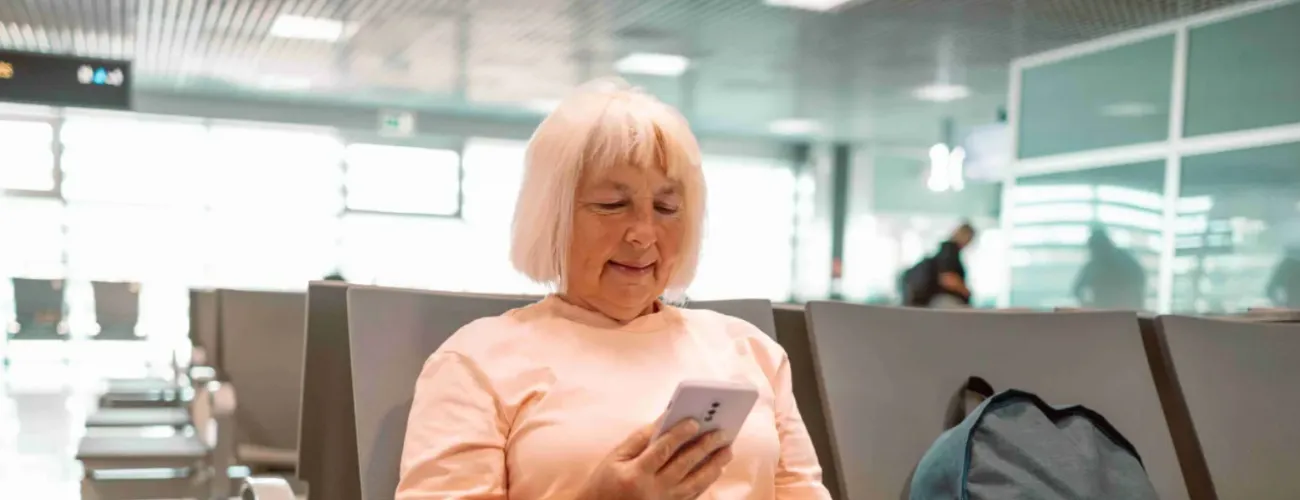 Une dame assise dans un aéroport regarde son passeport