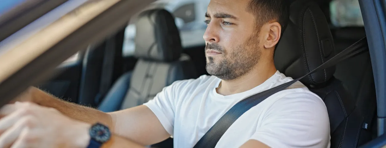 Un monsieur au volant de sa voiture