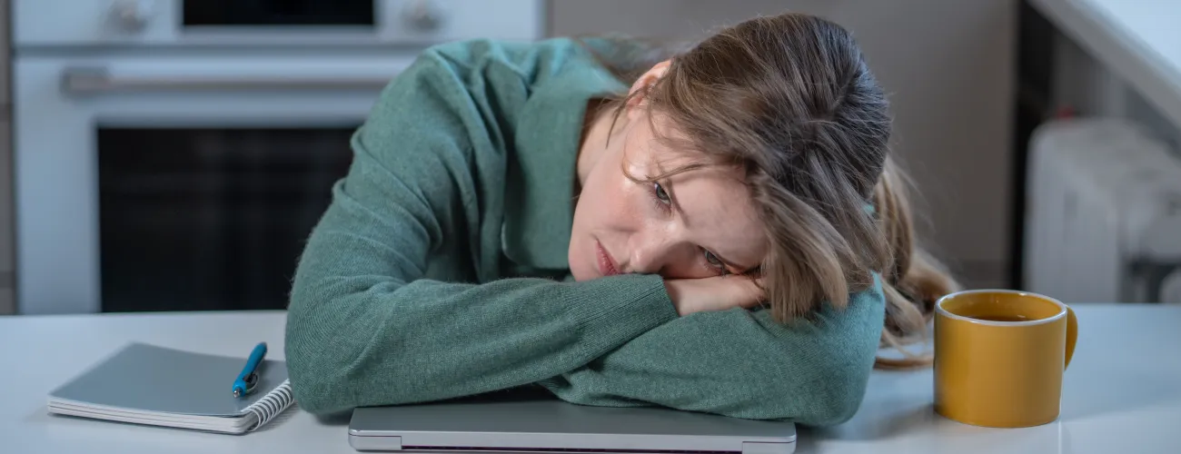 Une femme épuisée pose la tete sur sa table