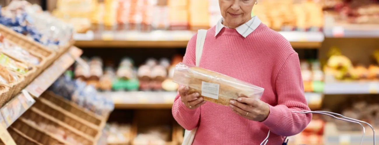une femme consulte l'étiquette d'un pain en magasin