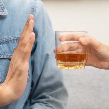 un  homme refuse un verre d'alcool