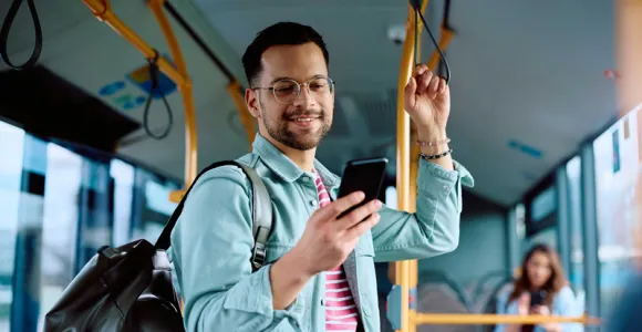 Un homme utilise l'app Ma MC dans un bus